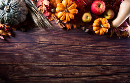 Autumn background decoration from dry leaves and pumpkin on dark wooden background. Flat lay, top view with copy space for Autumn, fall, Thanksgiving concept.の写真素材