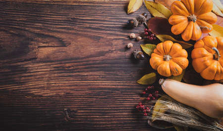 Autumn background decoration from dry leaves and pumpkin on dark wooden background. Flat lay, top view with copy space for Autumn, fall, Thanksgiving concept.の写真素材
