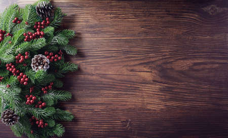 Christmas  branches decoration concept with berries, stars and pine cones on old wooden background. Flat lay, top view with copy space.の写真素材