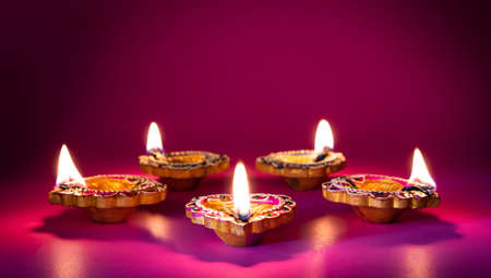 Happy Diwali - Clay Diya lamps lit during Dipavali, Hindu festival of lights celebrationの写真素材