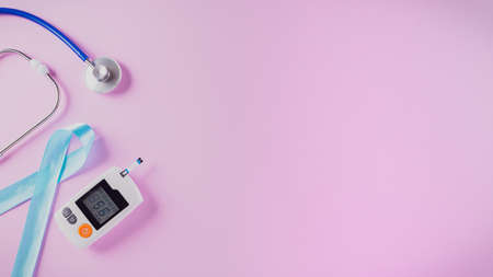 World diabetes day awareness concept, stethoscope with blue ribbon and diabetes measure set on pastel pink background, 14 November.の写真素材
