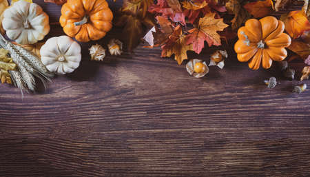 Thanksgiving background decoration from dry leaves and pumpkin on  wooden background. Flat lay, top...