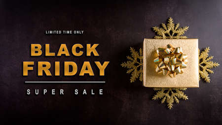 Top view of golden christmas boxes on dark stone background with copy space for text. Black Friday...