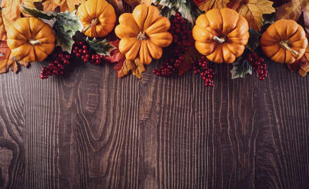 Thanksgiving background decoration from dry leaves and pumpkin on old wooden background. Flat lay, top view with copy space for Autumn, fall, Thanksgiving concept.の写真素材