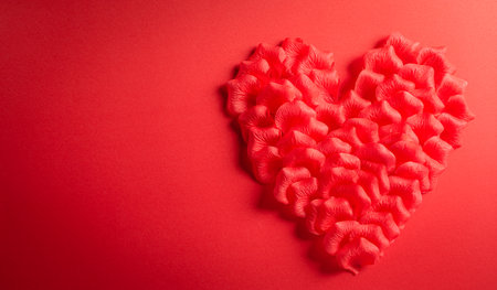 Love and Valentine's day concept. Red hearts made from rose petals on red paper background. Flat lay top view.の写真素材