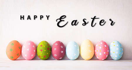 Happy easter decoration concept! Row Easter eggs on bright white wooden background.