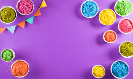 Happy holi festival decoration.Top view of colorful holi powder on purple  background with copy space for text.