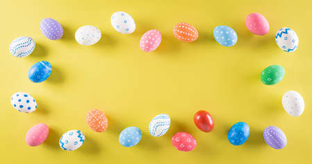 Happy easter! Colourful of Easter eggs on pastel yellow background. Greetings and presents for Easter Day celebrate time. Flat lay ,top view.の写真素材