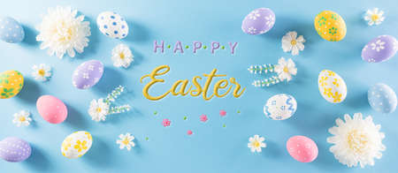 Happy easter! Colourful of Easter eggs in with flower on pastel blue background. Greetings and presents for Easter Day celebrate time. Flat lay ,top view.の写真素材