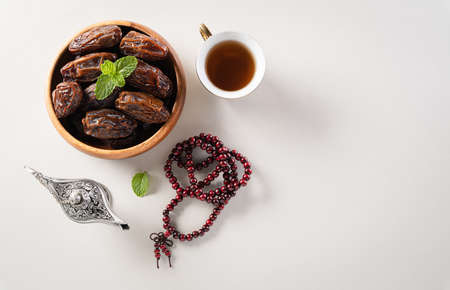 Table top view image of decoration Ramadan Kareem,  dates fruit, aladdin lamp and rosary beads on gray  background. Flat lay with copy space.の写真素材