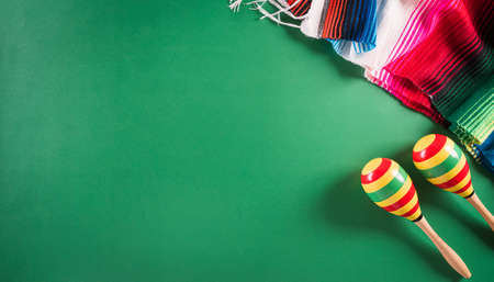 Cinco de Mayo holiday background made from maracas, mexican blanket stripes or poncho serape on green background.の写真素材