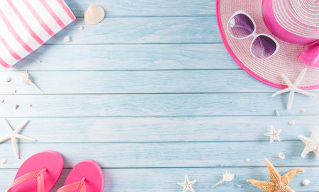 Summer holiday, travel and vacation concept. Sunglasses, starfish, beach hat, flip flop and sea shell on pastel blue wooden background.の写真素材
