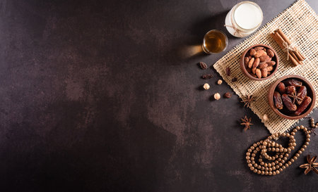 Table top view image of decoration Ramadan Kareem, dates fruit, milk and almond on dark stone background. Flat lay with copy space.の写真素材
