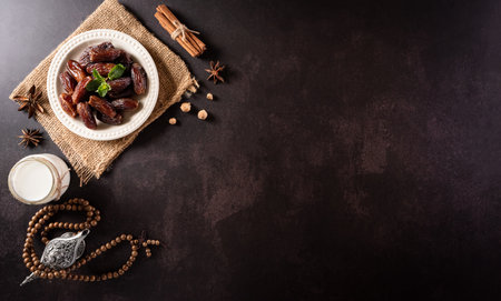 Table top view image of decoration Ramadan Kareem, dates fruit, aladdin lamp and rosary beads on dark stone background. Flat lay with copy space.の写真素材