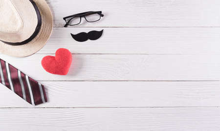 Happy Father's Day decoration with colorful tie with mustache, red heart and hat on white wooden background.の写真素材