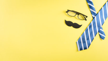 Happy Father's Day background concept with blue tie, glasses and  mustache on pastel yellow background.の写真素材