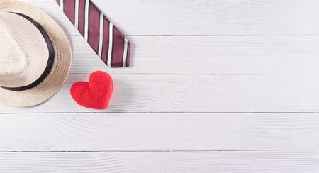 Happy Father's Day decoration with colorful tie with red heart and hat on white wooden background.の写真素材