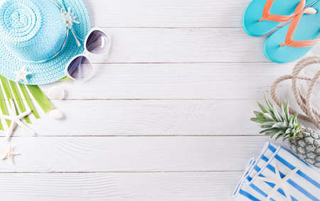 Summer holiday, travel and vacation concept. Sunglasses, starfish, beach hat, and seashell on white wooden background.の写真素材