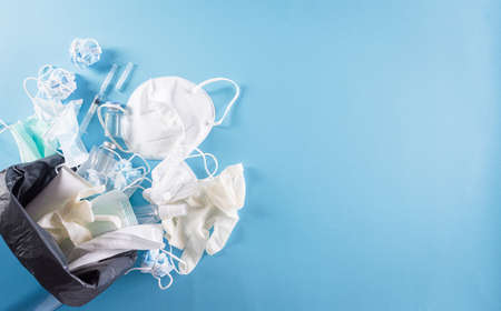Covid-19 plastic waste and garbage, disposable masks, medicl glove, alcohol gel bottle and needle in trash bin. Pile of used personal protective equipment PPE. Pollution by surgical masks during the coronavirus pandemic.の写真素材
