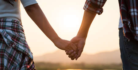 Soft focus of two partner holding hand in front of the mountain during sunset. Friendship, Happiness, Leisure, Partnership and team Concept.の写真素材