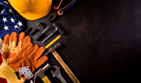 Happy Labor day concept. American flag with different construction tools on dark stone background.の写真素材