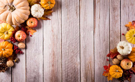 Autumn composition. Pumpkin, cotton flowers and autumn leaves on dark wooden background. Flat lay, top view with copy spaceの写真素材