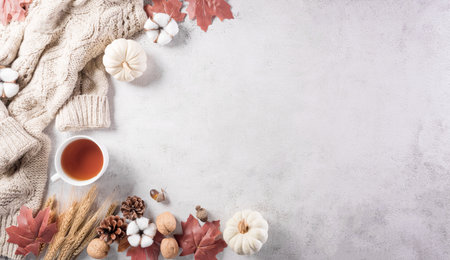Autumn composition. Pumpkin, cotton flowers, autumn leaves and sweater on stone background. Flat lay, top view with copy space.の写真素材