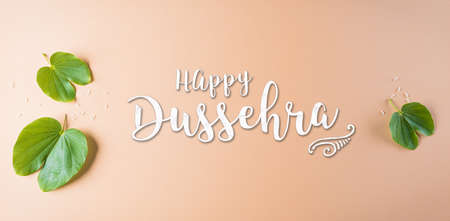 Happy Dussehra. Green leaf with the text on orange pastel background. Dussehra Indian Festival concept.の写真素材