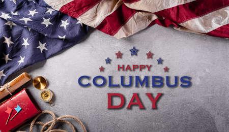 Happy Columbus Day concept. Vintage American flag, compass, paper boat, rope on dark stone background.  Flat lay, top view with copy space.の写真素材