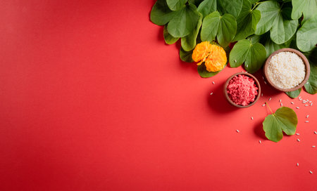 Happy Dussehra. Yellow flowers, green leaf and rice on red background. Dussehra Indian Festival concept.の写真素材