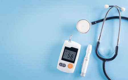 Healthcare and medical concept, Stethoscope and blood glucose meter sets on blue background, World Diabetes day, 14 November.の写真素材