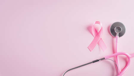 Pink ribbon and stethoscope on pastel pink background, Symbol of womens breast cancer awareness, Health care and medical concept.の写真素材