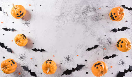 Halloween decorations made from pumpkin, paper bats and black spider on stone background. Flat lay, top view with copy space for text.の写真素材