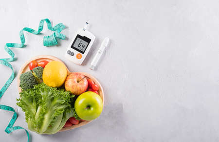 World diabetes day and healthcare concept. Diabetic measurement set, measure tape and healthy food eating nutrition in plate on stone background.の写真素材