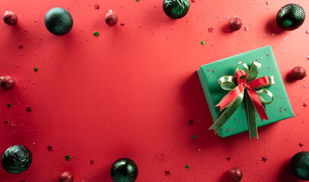 Christmas and new year background concept. Top view of Christmas gift box and christmas ball on red background.の写真素材