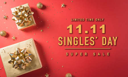 Online shopping of China, 11.11 singles day sale concept. Top view of golden christmas gift boxes with ribbon on red background with the textの写真素材