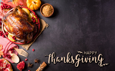 Thanksgiving dinner background concept with turkey roasted and all sides dishes, fall leaves, pumpkin and seasonal autumnal decor with the text on dark stone background.の写真素材