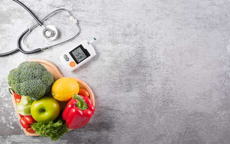 World diabetes day and healthcare concept. Healthy food eating nutrition in plate, stethoscope and diabetic measurement test set on stone background.の写真素材