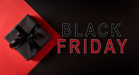Top view of Christmas boxes with black ribbon on black and red background with the text. Black Friday composition.の写真素材