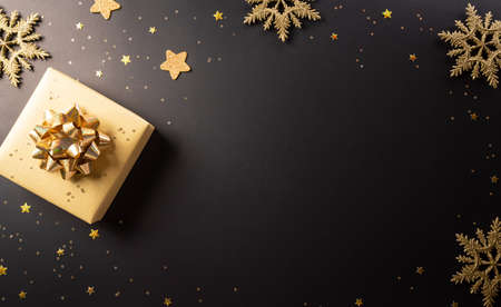 Top view of Black Friday Christmas gift box and golden snowflake on dark background. Shopping...