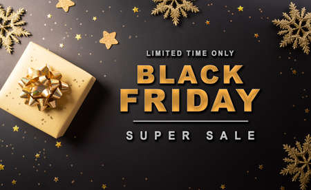 Top view of Black Friday Christmas gift box and golden snowflake on dark background. Shopping concept boxing day and Black Friday composition.の写真素材