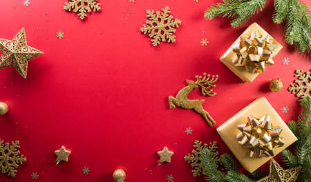Christmas and new year background concept. Top view of Christmas gift box, reindeer, christmas ball and snowflake on red background.の写真素材