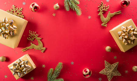 Christmas and new year background concept. Top view of Christmas gift box, reindeer, christmas ball and snowflake on red background.の写真素材