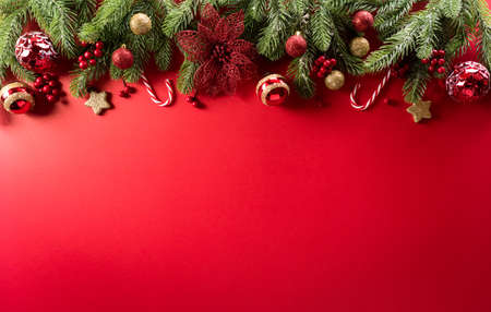 Christmas and new year background concept. Top view of Christmas decoration made from snowflake, christmas ball and  pine branches on red background.の写真素材
