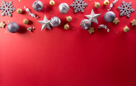Christmas and new year background concept. Top view of Christmas decoration made from snowflake, christmas ball and  star on red background.の写真素材