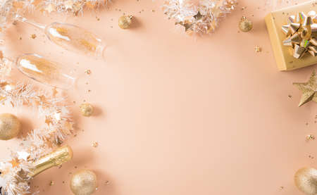 Happy New year celebration background concept. Golden gift box, stars, christmas ball and champagne on pastel background.の写真素材