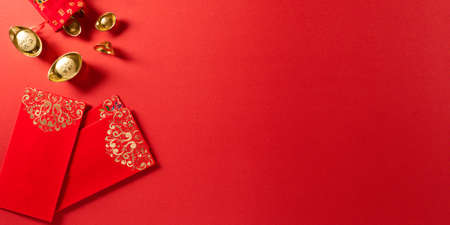 Chinese new year festival decorations pow or red packet and gold ingots or golden lump on a red background. Chinese characters FU in the article refer to fortune good luck, wealth, money flow.の写真素材