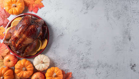Thanksgiving dinner background concept with turkey roasted and all sides dishes, fall leaves, pumpkin and seasonal autumnal decor on stone background, top view, copy space.の写真素材