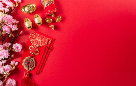 Chinese new year decorations made from red packet, orange and gold ingots or golden lump on a red background. Chinese characters FU in the article refer to fortune good luck, wealth, money flow.の写真素材