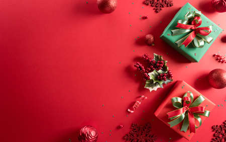 Christmas and new year background concept. Top view of Christmas decoration made from gift box, snowflake, christmas ball and  pine branches on red background.の写真素材
